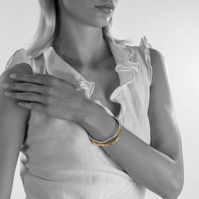 handmade ethical jewellery. organic styled thick bangle in silver and gold plated silver.