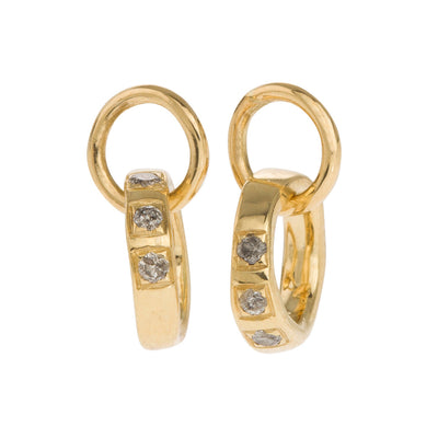 Classic, Twisted Hoop Earrings in Gold. The Classic Twist circles can be purchased plain or with diamonds. All diamonds are set in pave style framed in a squared line: three diamonds sit together on one side and one diamond on the opposite side. All diamonds are natural in colour and available in black, grey or brown, depending on the metal. The earrings come in White Gold, Yellow Gold, 18K and 9K Gold.